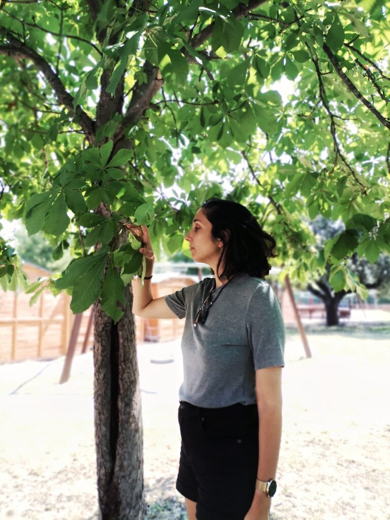 Laura observando las hojas de un árbol